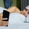 Frau mit Smartphone im Bett